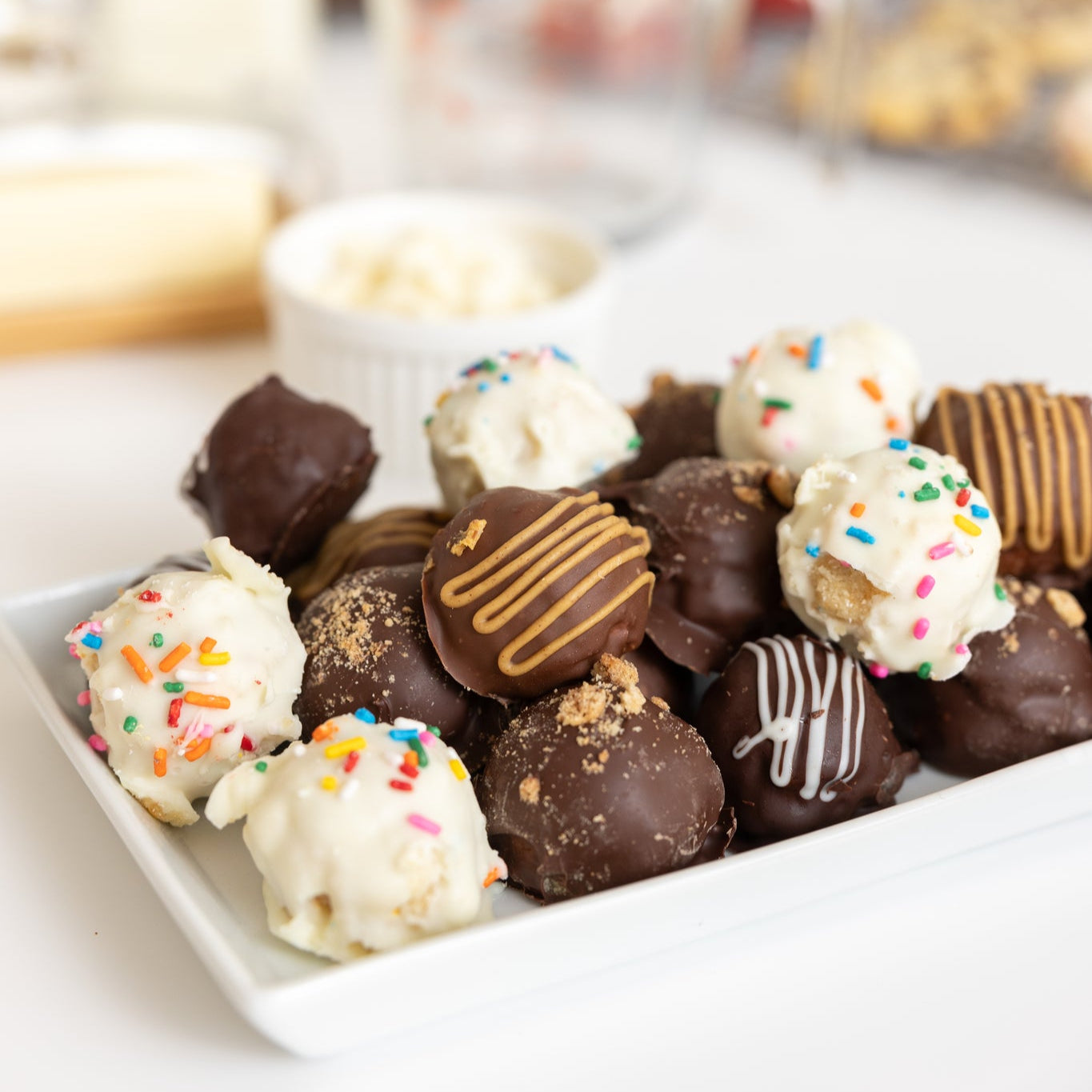Handmade giant stuffed truffles on a plate. They look similar to cake pops. A very unique sweet treat.