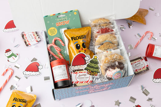 Box of snacks with Christmas-themed decorations on a white background