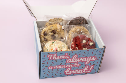 Open treat box filled with individually wrapped cookies in various flavors, including chocolate chip, cookies & cream, red velvet, and confetti cake. The box exterior reads, "There's always a reason to treat!" against a blue background with sprinkles.