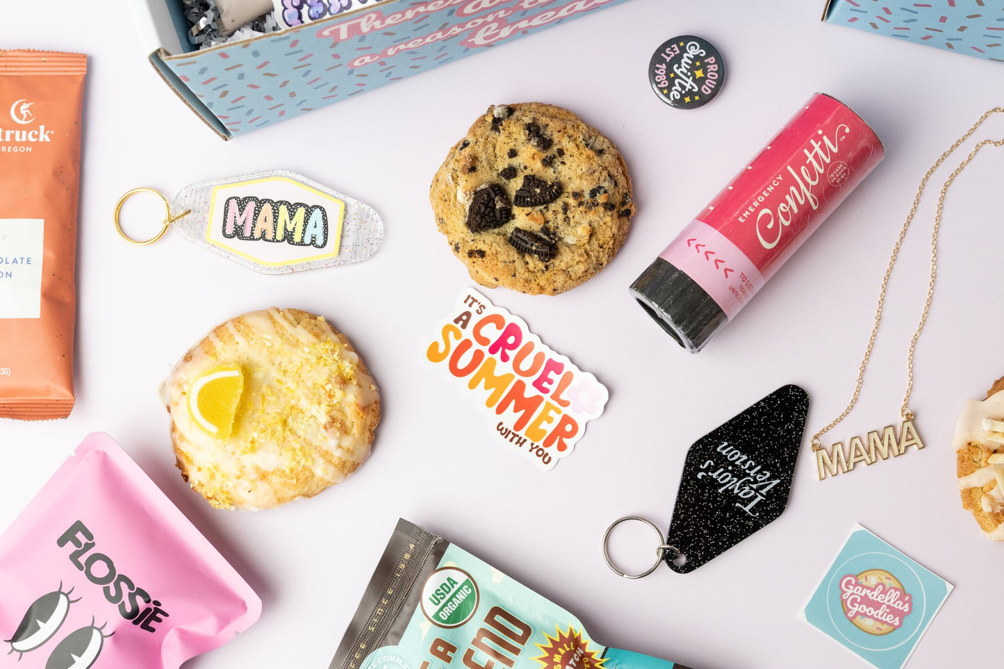 Assorted items including cookies, confetti, keychains, and stickers on a white surface.